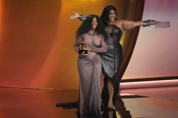 Lizzo, a la derecha, entrega el premio a la Mejor Canción R&B a SZA 